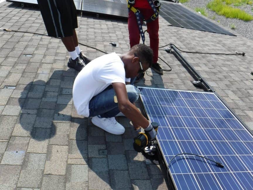 student practicing a solar panel installation