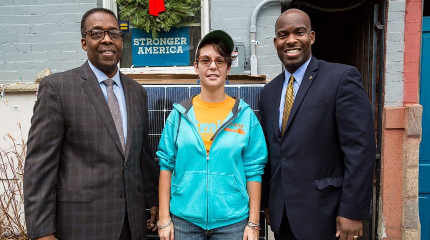 Council President Darrell Clarke and Councilmember Derek Green stand with Kate Zmich who had solar panels installed with Solarize Philly