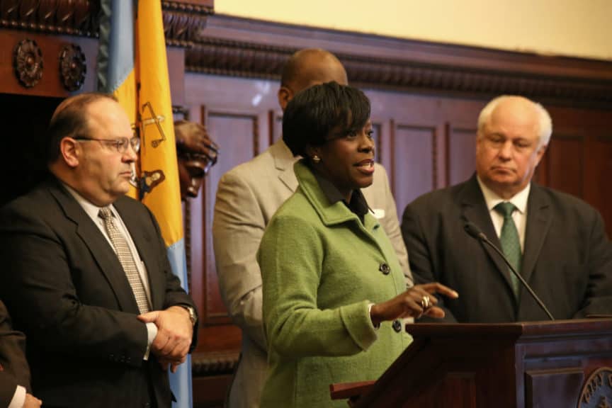 Councilmember Cherelle Parker speaks at the podium while Councilmembers Domb and Taubenberger look on
