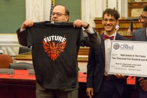 Councilmember Domb holding a tshirt that reads Future with a bird graphic underneath