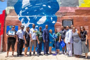 Council president Darrell Clarke stands with community members in front of the mural