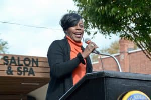 Councilmember Cherelle Parker speaks at a podium outside of a salon