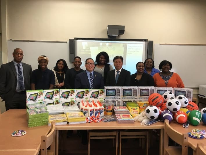 Councilmember David Oh and others with various donated school supplies