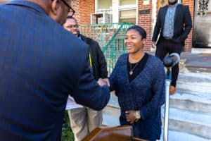 Council President Clarke shakes hands with a new homeowner