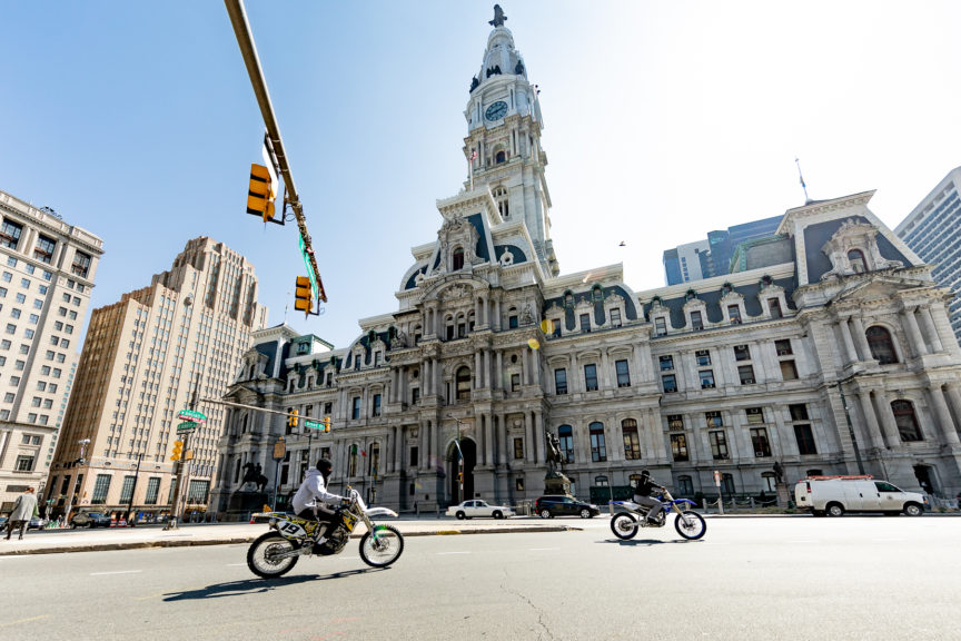 Philadelphia city hall from the street with 2 dirt bike riders going by